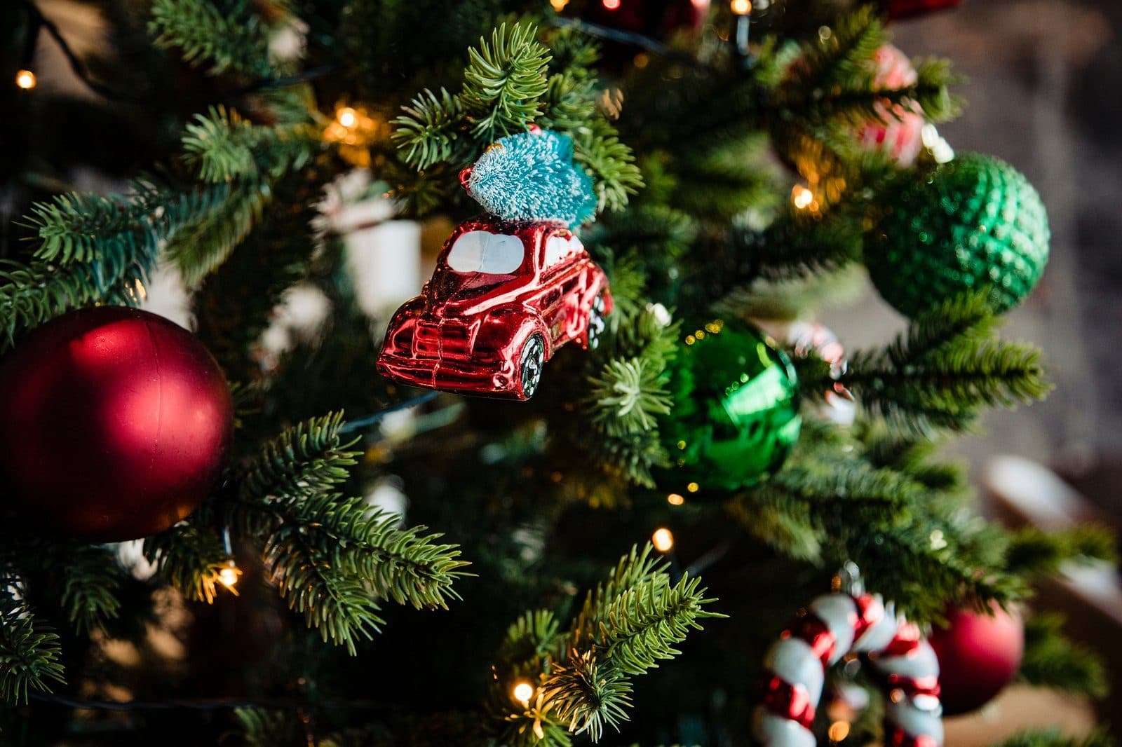 Kerstballen en ornamenten in een kunstkerstboom voor een raam